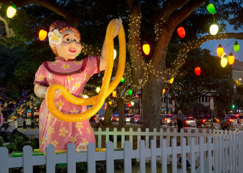 Thousands of colourful lights in Waikiki. Hula dancer with a necklace of flowers.