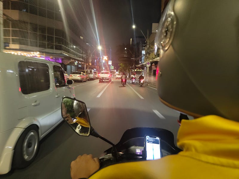 On the back of a Grab motorsai at night. 📸: the author.