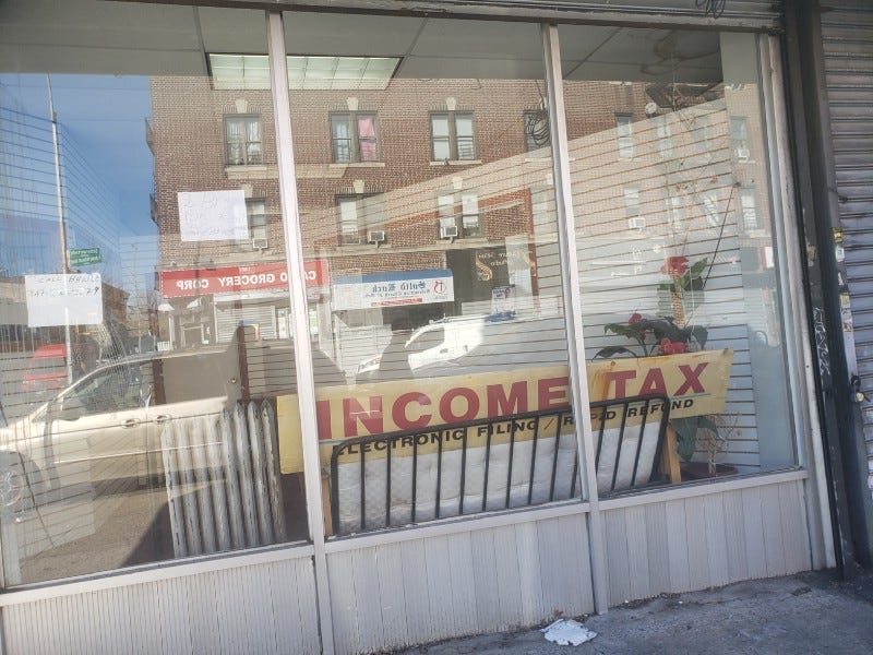 Storefront window with a sign reading “Income Tax”