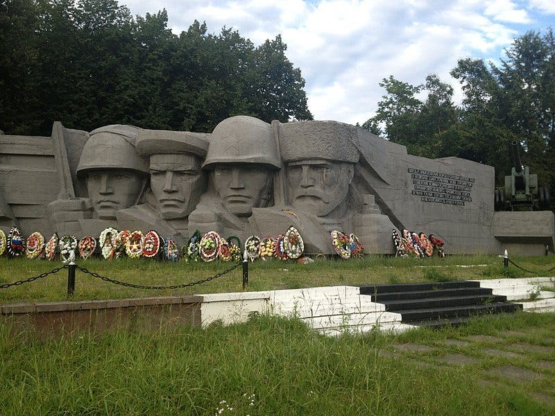 A memorial with the faces of four men carved into concrete