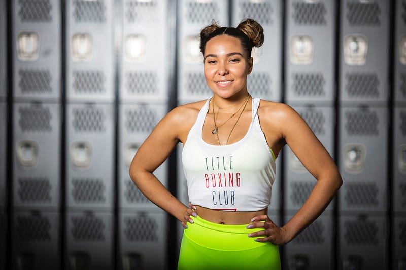 A fit woman wearing a white tank top.
