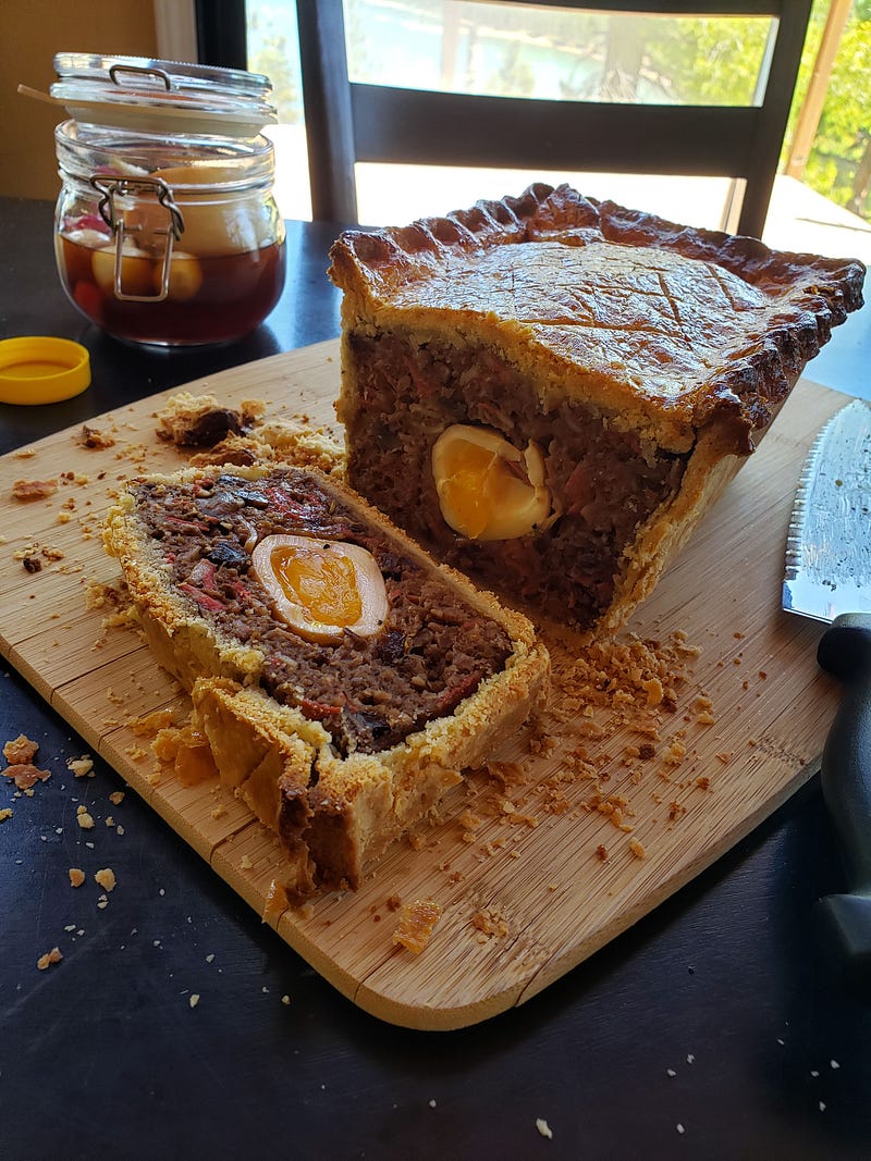 A cut open meat pie on a cutting board.