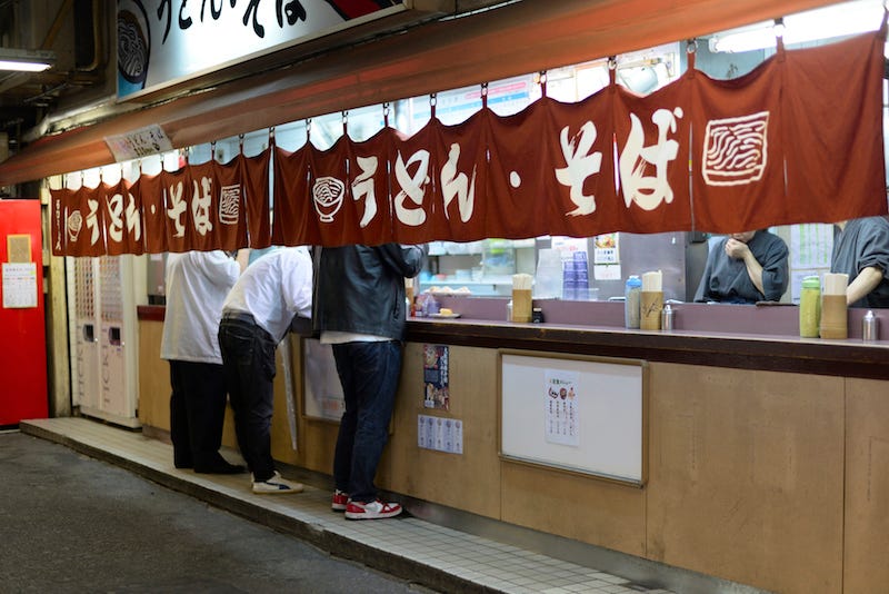 Budget travelers enjoy a bowl of udon for cheap in Japan