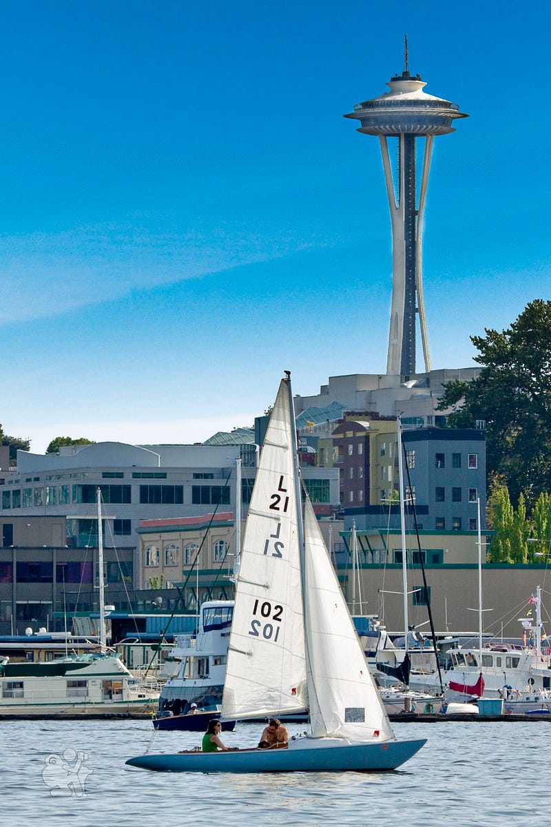 A small sailboat passes under the Seattle Space Needle A small sailboat passes under the Seattle Space Needle