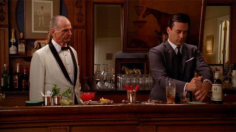 Don Draper stands at a bar with Conrad Hilton making the pair an Old Fashioned cocktail.