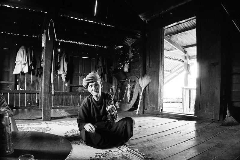 A Chinese Farmer sitting on a carpet on the floor