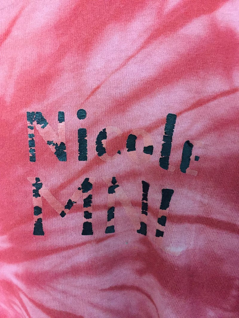 A red tie dye shirt with the name Nicole on it.