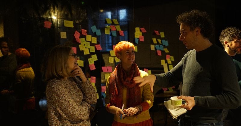 An image showing people at a Catalyst / CAST event, with post-it notes in the background