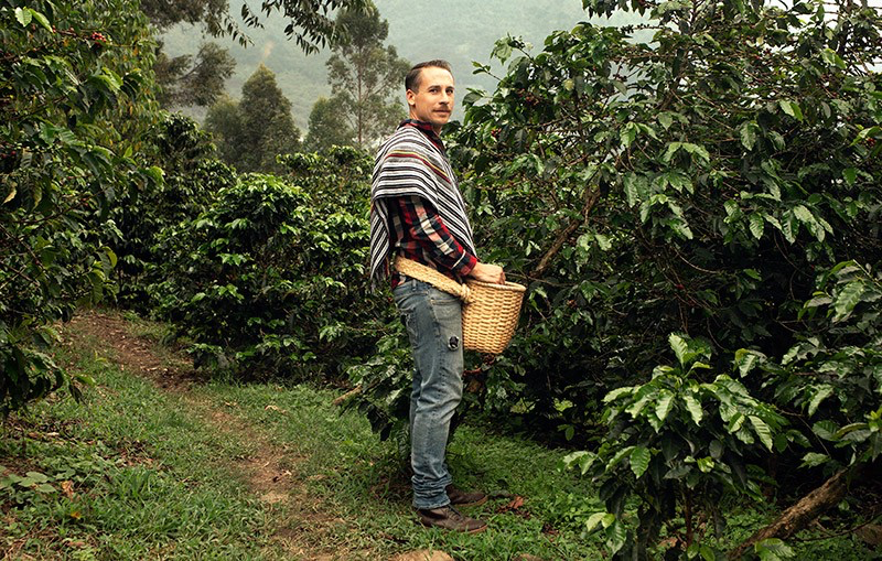 Esteban Monzon stands near the bushes at La Casa Grande, his family’s coffee farm in Colombia.