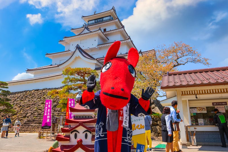 Aizu-Wakamatsu’s red bull mascot, Akabeko, stands in front of Tsuruga Castle in Fukushima Prefecture