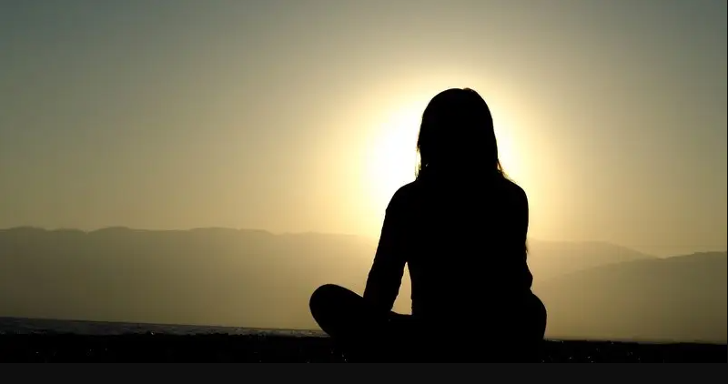 girl meditating at sunset