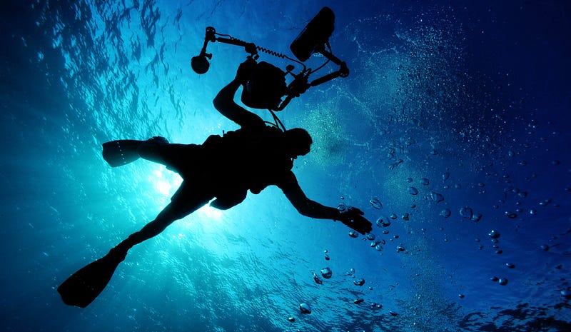 a man diving with a camera holding in is right hand