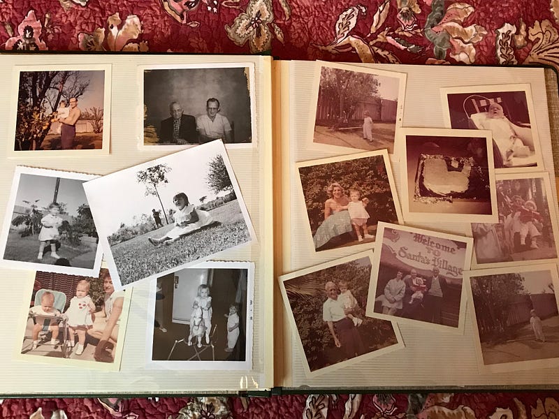 The image is a photograph of two pages of my disheveled photo album showing some of my baby pictures and pictures of family members.