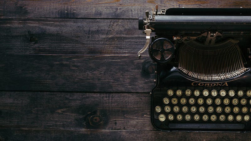 An antique typewriter on a old wooden desk