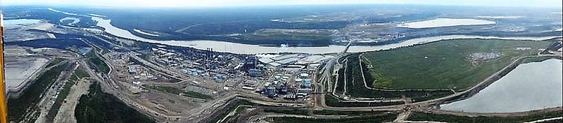Suncor’s Millenium Steepbank upgrader plant beside Athabasca river with reclaimed pond on right