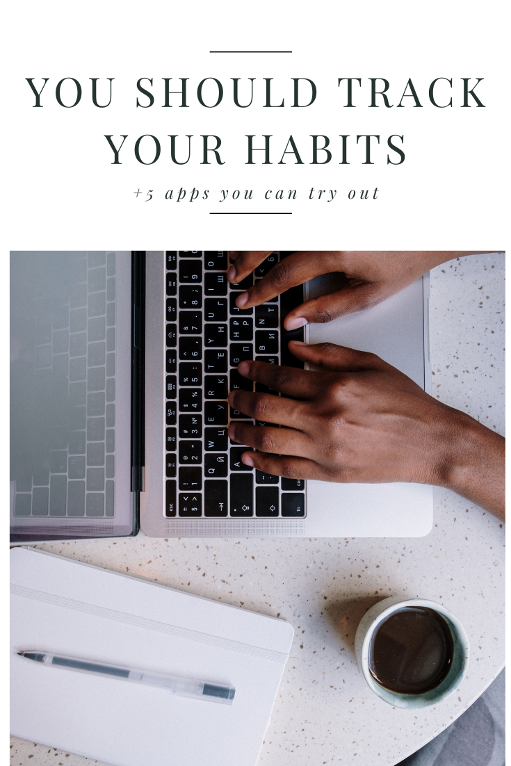 Woman typing on her laptop with a notebook placed next to her — why you should be tracking your habits and how it can help you work toward your goals.