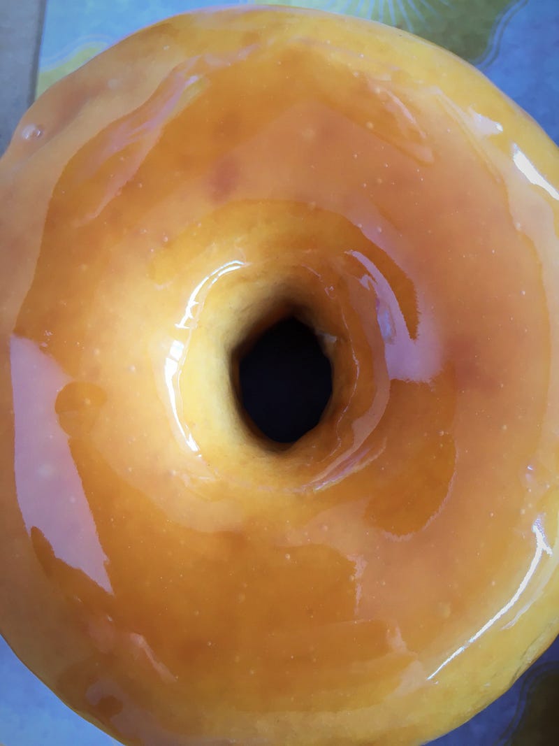 Honey Caramel doughnut with a glaze so shiny you can almost see your reflection on it.