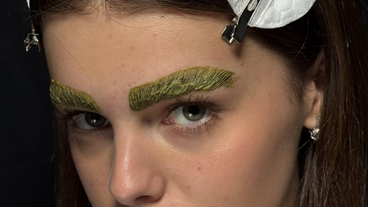 A woman with green eyebrows, showcasing a unique and bold style.
