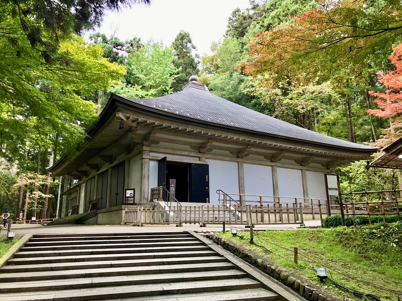 Simple temple building surrounded by trees.
