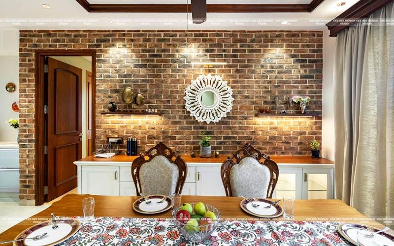 Interior of dining room with brick wall and table.