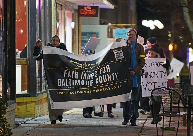 Coalition members during the candlelight march. Banner reads, “Uphold the Voting Rights Act; Fair Maps for Baltimore County; Stop Diluting the Minority Vote.” (photo by Kenneth K. Lam/The Baltimore Sun)