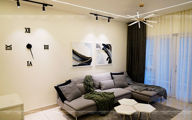 A contemporary living room featuring a stylish couch, a sleek clock, and a chic lamp