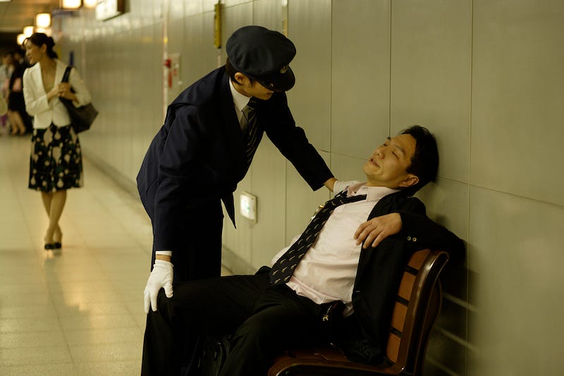 A Japanese salaryman passes out at the station after a long night of partying in Japan