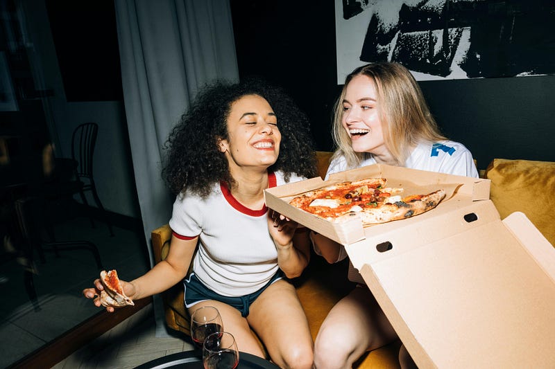 Two women eating pizza