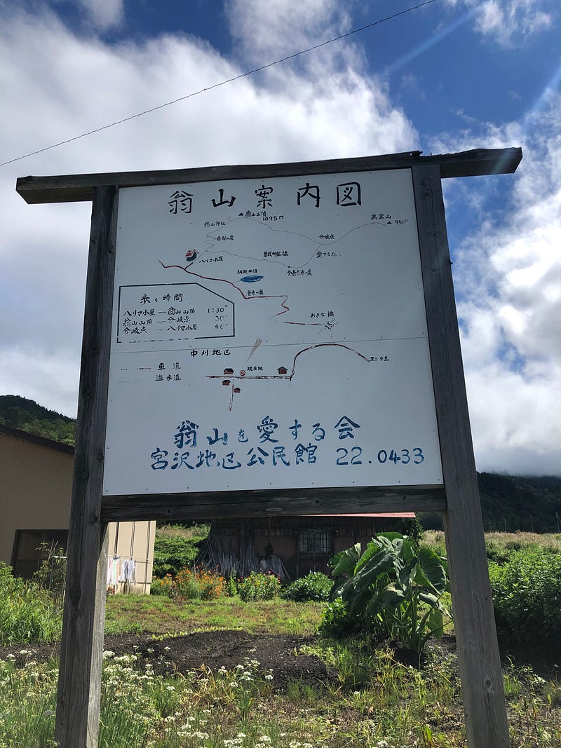 A sign in the Myokoji Hamlet showing the way to the Okina-san trailhead