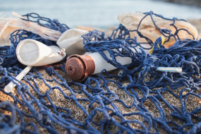 Photo of plastic waste caught up in a fisher’s net. Photo by Angela Compagnone on Unsplash