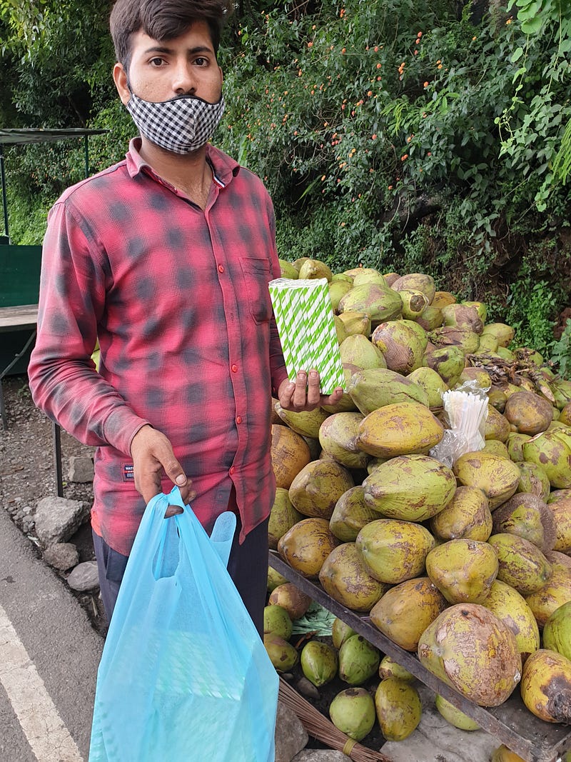 Coconut seller with paper straws in Dharamshala, India