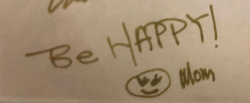 In handwriting: “Be HAPPY! (smiley face with eyelashes) Mom”