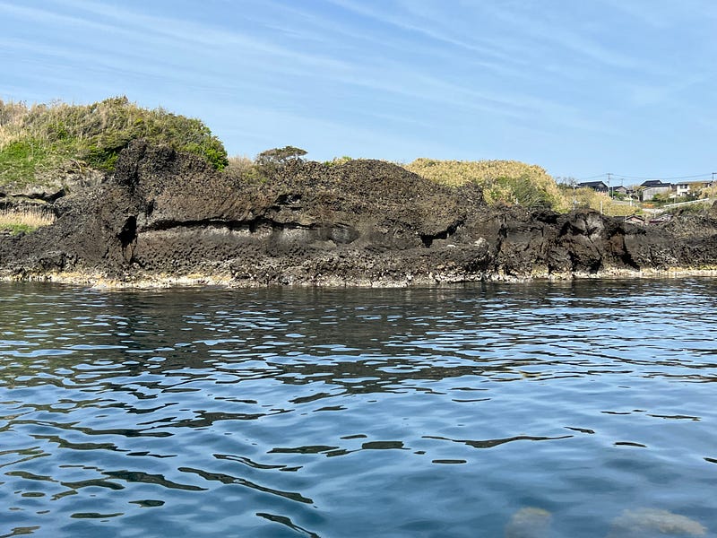 Coastal cliffs show horizontal indentation of the former waterline along the southeastern coast of Sado Island.