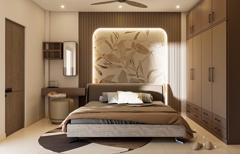 This modern master bedroom interior design by ArchitectsHive reflects elegance, comfort, and smart space planning. The design features a stylish upholstered bed, decorative backlit wall panel with botanical artwork, vertical wooden slats, and warm ambient lighting that creates a relaxing atmosphere. A sleek wardrobe system, compact dressing area, and neutral colour palette enhance functionality and aesthetics.