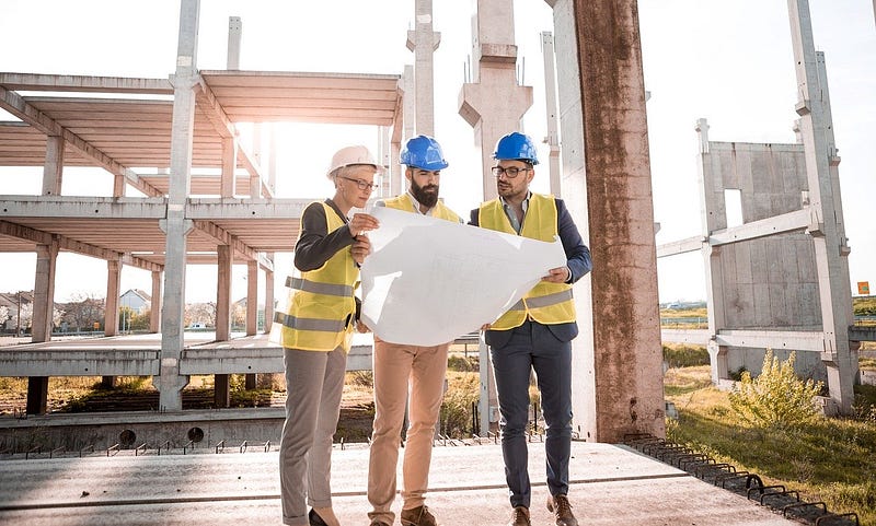 3 builders looking at plans.