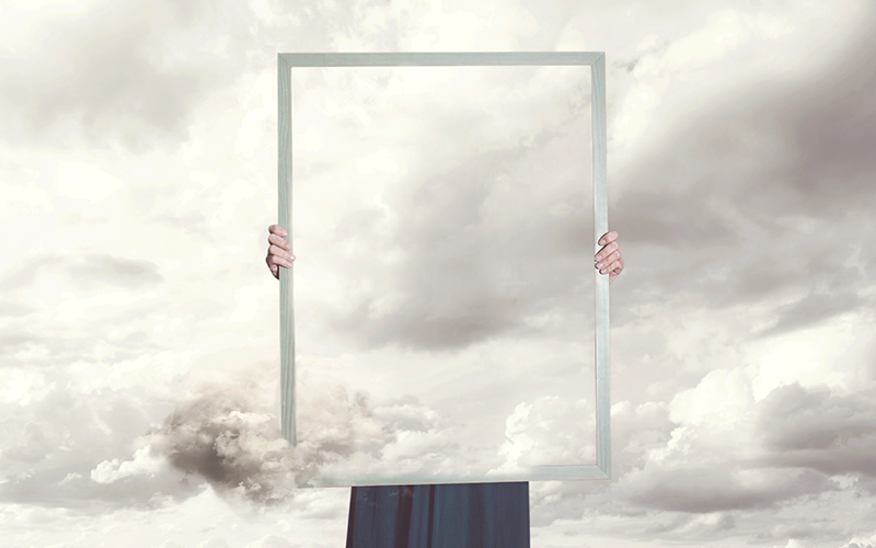 Capton: Surreal moment of a woman hiding behind a picture of clouds equal to the landscape. Credit: fcscafeine/iStock.com