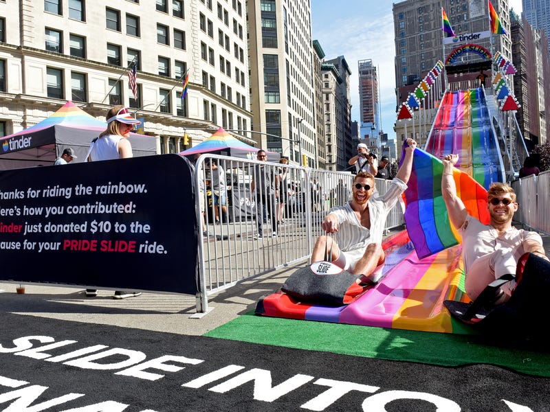 Tinder’s 30-foot rainbow Pride slide has a very serious message.