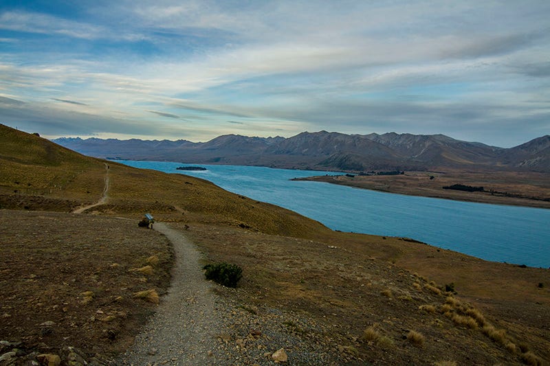 Path along a mountain lakeshore, stretching into the distance