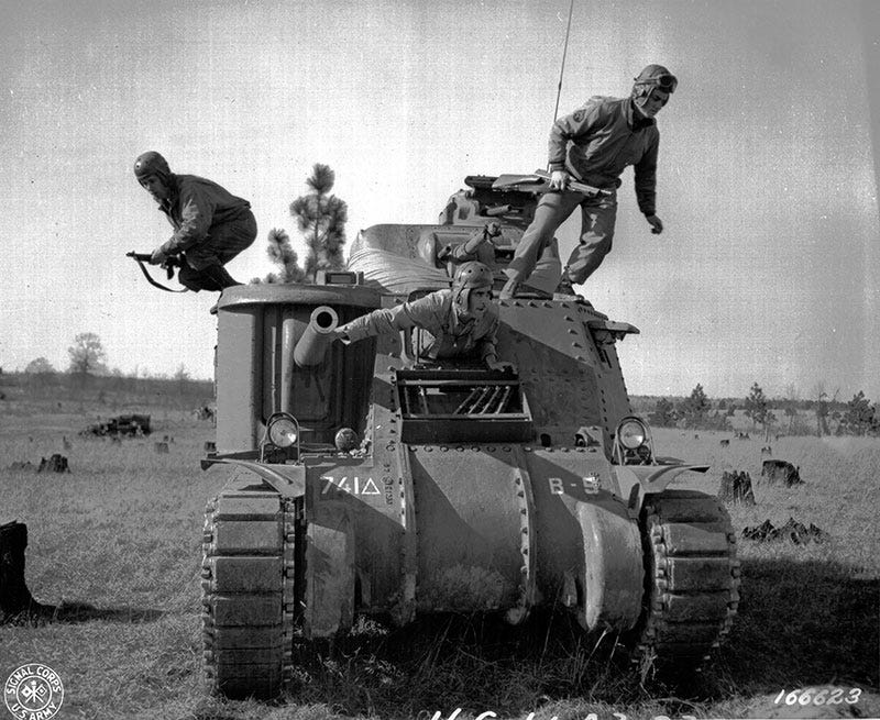 Black and white photo of three men jumping out of a tank.