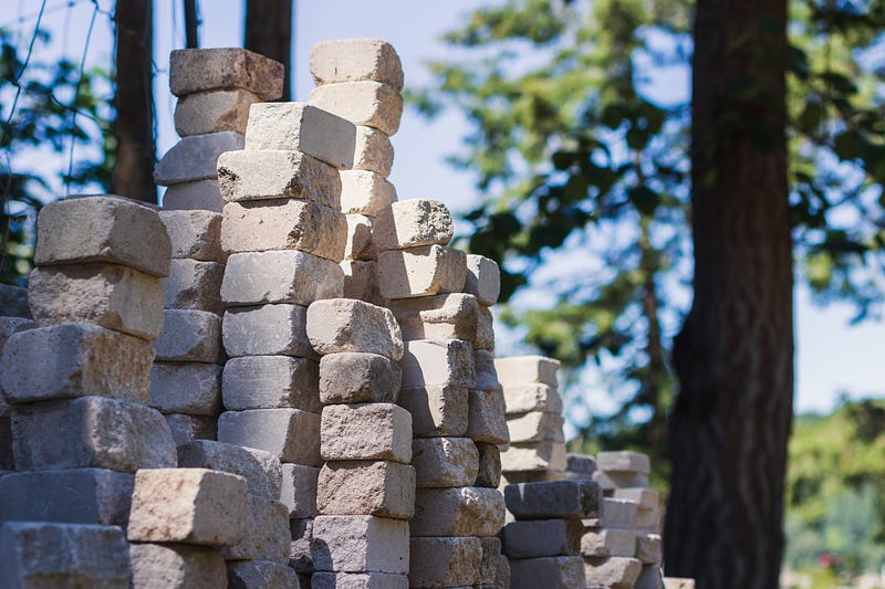 A stack of white bricks in the middle of the forest.