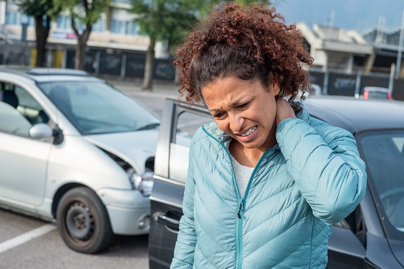 woman experiencing neck pain from a car crash.