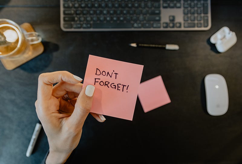 A picture of a hand holding a note that says Don’t Forget!
