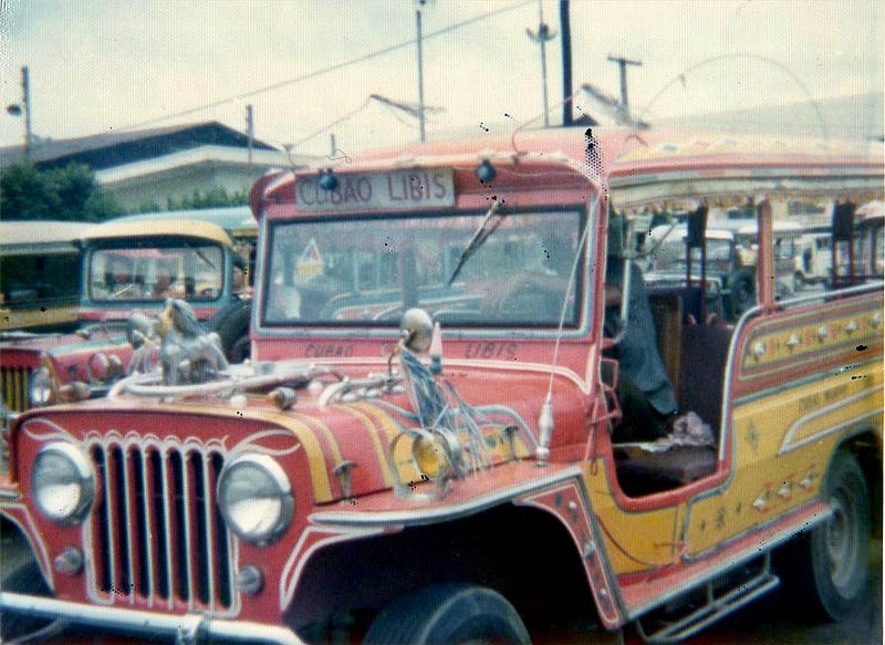 Long colorfully painted jeep decorated with tassels used as a passenger vehicle in the Philippines.