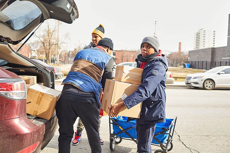 Volunteers taking boxes out of a car