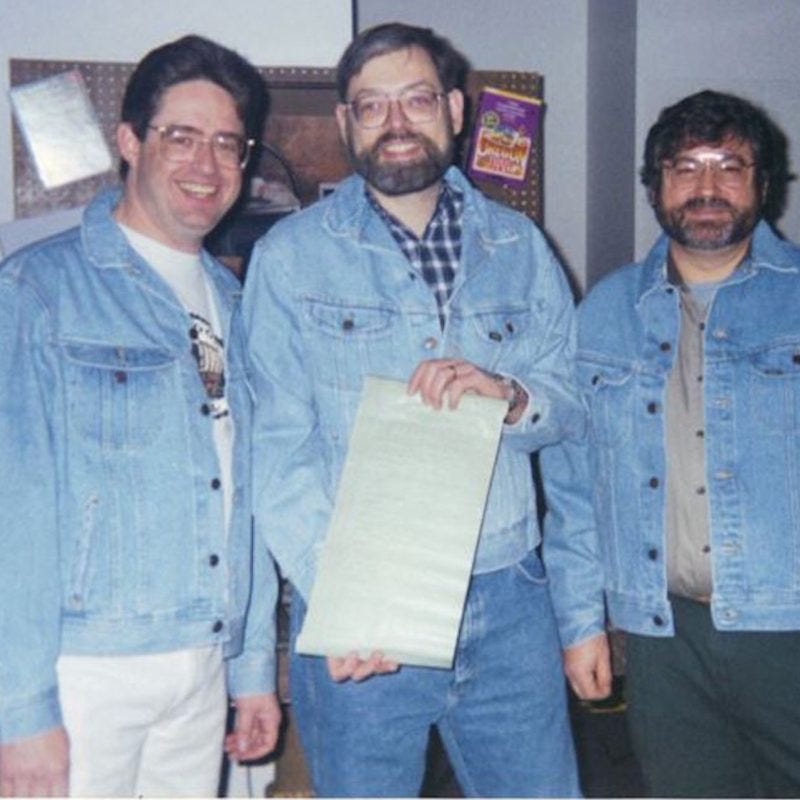 Three Minnesota teachers, and original creator of the Oregon Trail video game, holding a print out of their original 1971 source code -From left to right: Don Rawitsch, Bill Heinemann and Paul Dillenberger