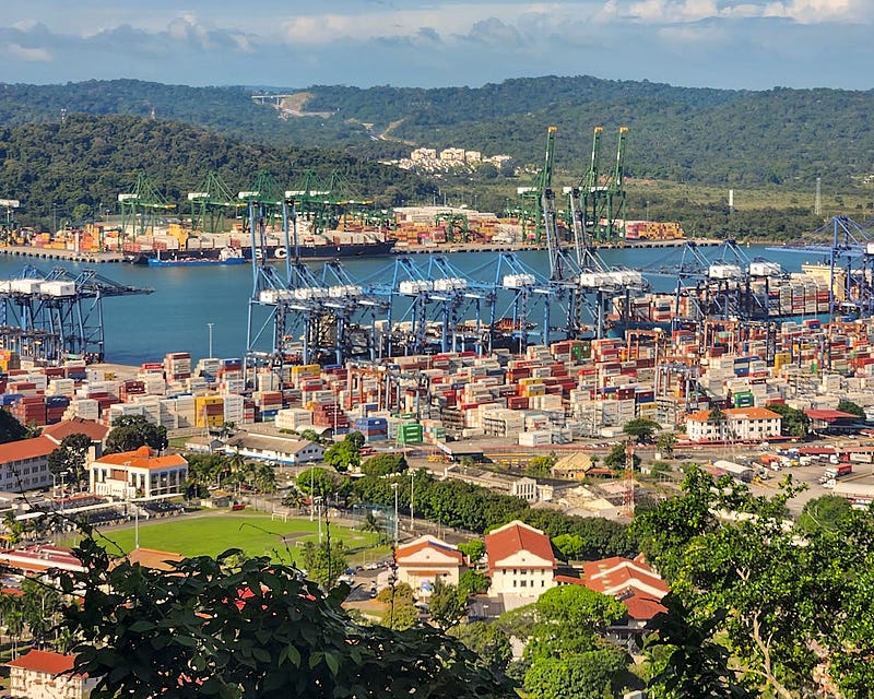 Busy canal and shipyard filled with storage containers.