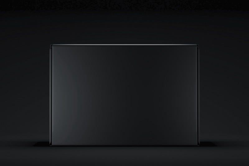 Uma caixa preta que abre por cima, você levantando a tampa, está na posição vertical, na frente de um fundo preto chapado
