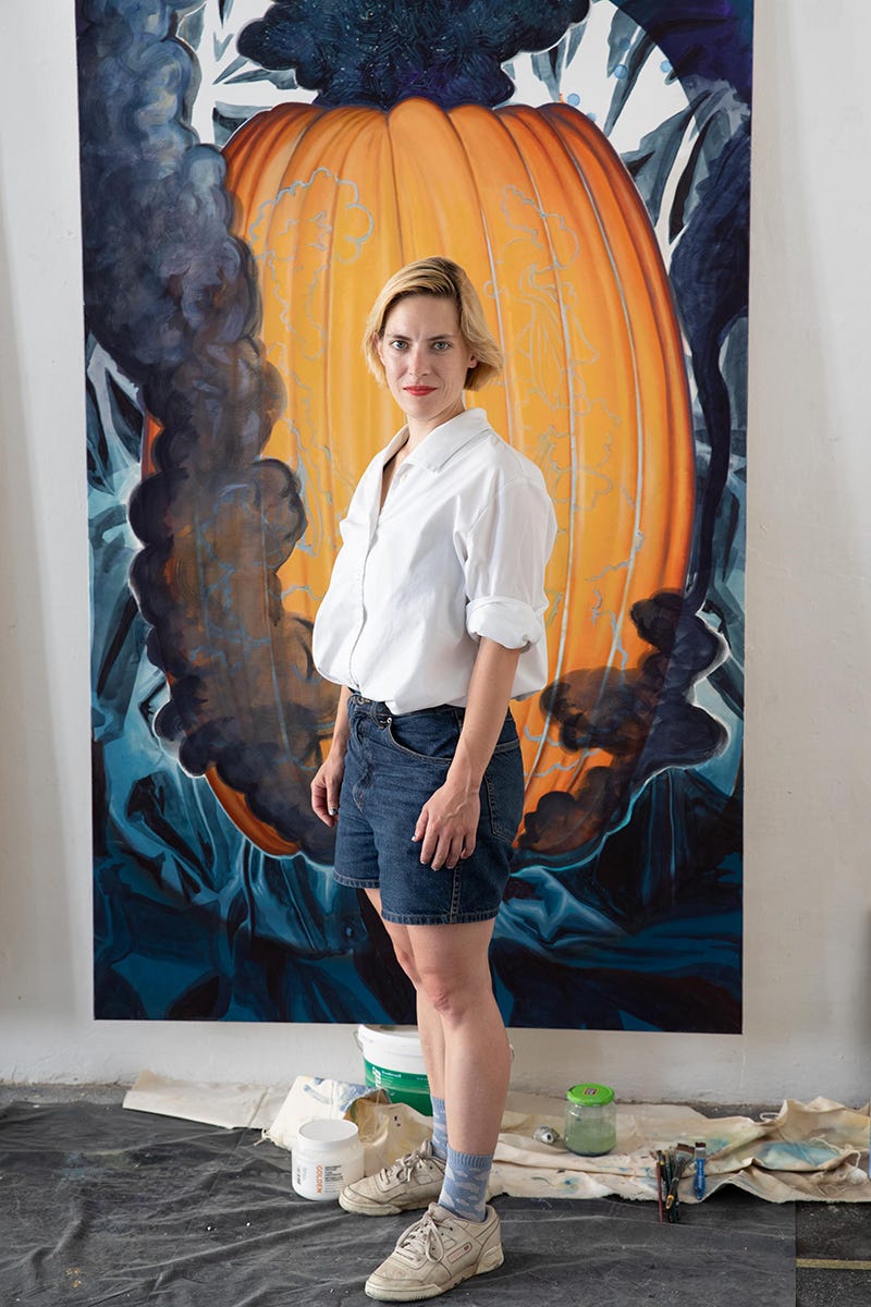 Titania Seidl portrait, emerging female artist from vienna, austria, behind a painting with a yellow pumpkin