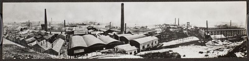 Black and white photograph of Levinstein’s Blackley works, featuring factory outhouses and tall chimneys.