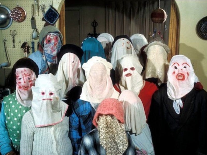A group of mummers in masks made from bedsheets